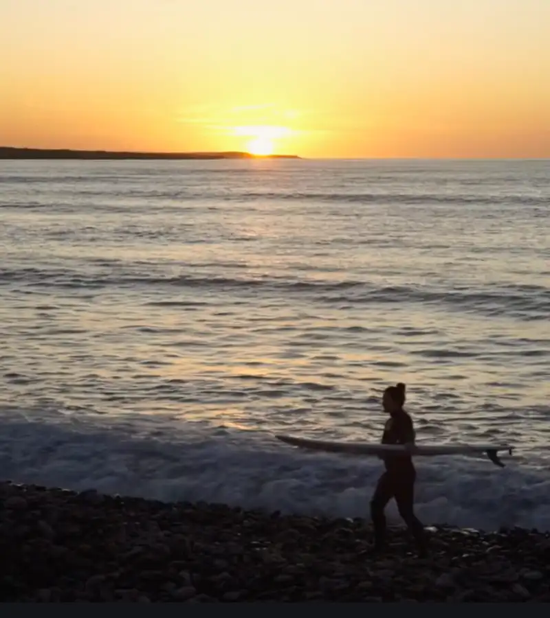 Aerial drone videography of a surfer at sunset