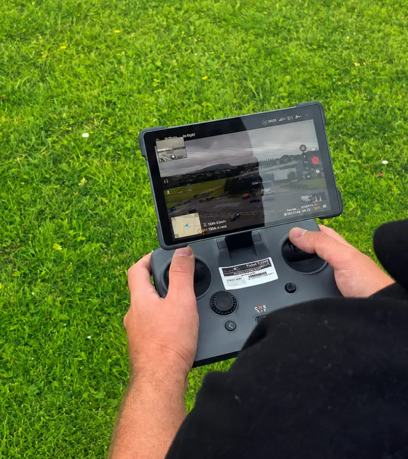 Drone operator using a remote controller to capture aerial footage in Ireland